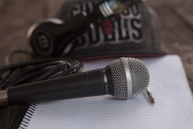 Een microfoon ligt op een kladblok met een pen en hoofdtelefoon